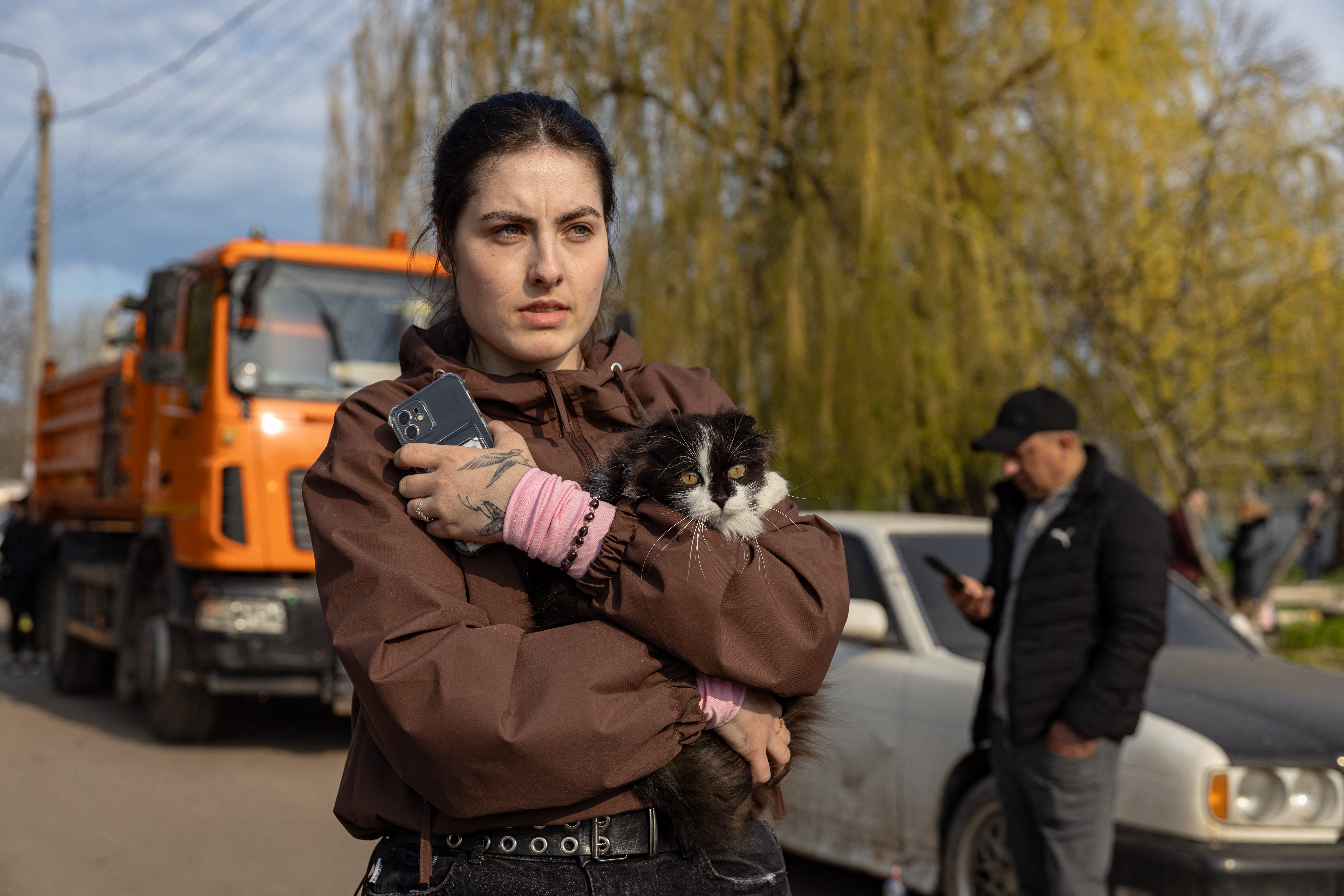 Uma moradora local, segurando seu gato, está no local de um ataque aéreo em Odessa, em 16 de abril de 2026, em meio à invasão russa da Ucrânia. Um ataque maciço de drones e mísseis russos matou pelo menos 16 pessoas em cidades por toda a Ucrânia.
