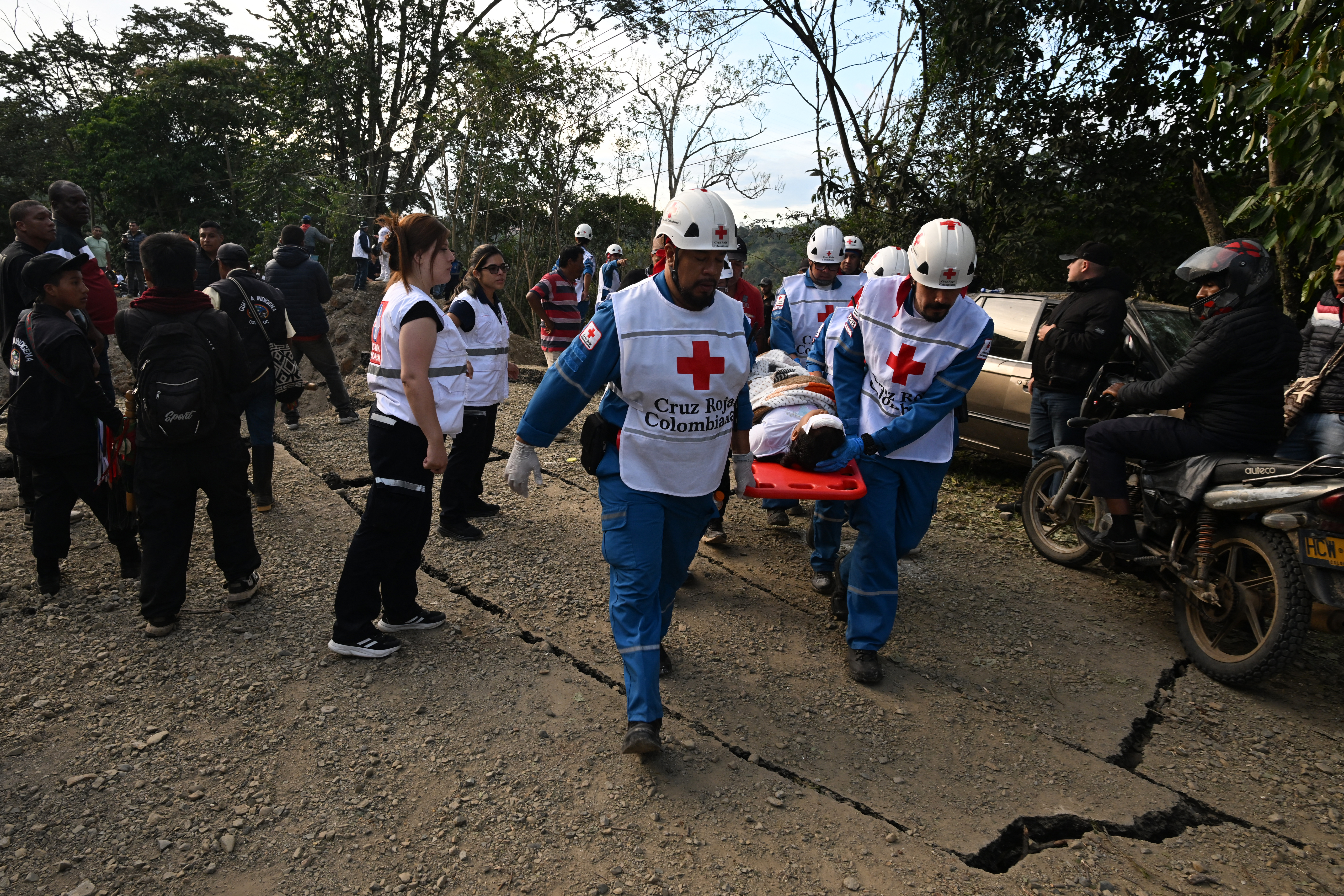 Trabalhadores da Cruz Vermelha carregam um ferido em uma maca após um ataque a bomba em El Tunel, na estrada Popayán-Cali, em Cajibio, departamento de Cauca, Colômbia, em 25 de abril de 2026.