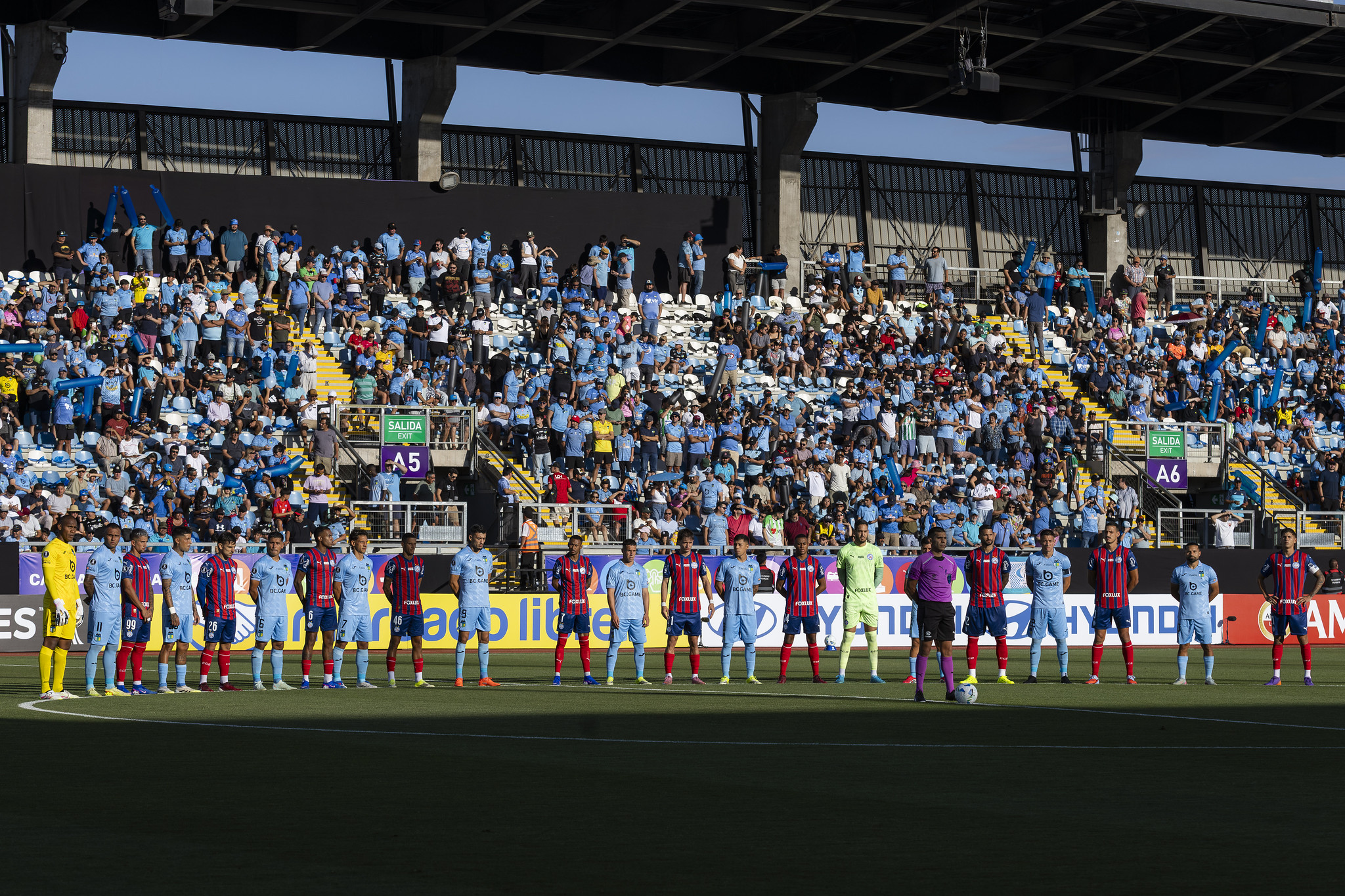 Equipes abraçadas em campo no Chile