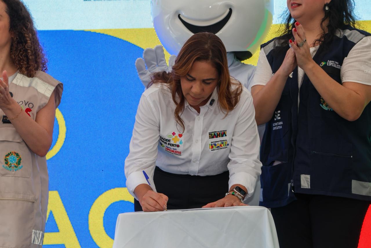 Secretária Roberta Santana assinando documento que autoriza liberação de recursos para a Bahia.