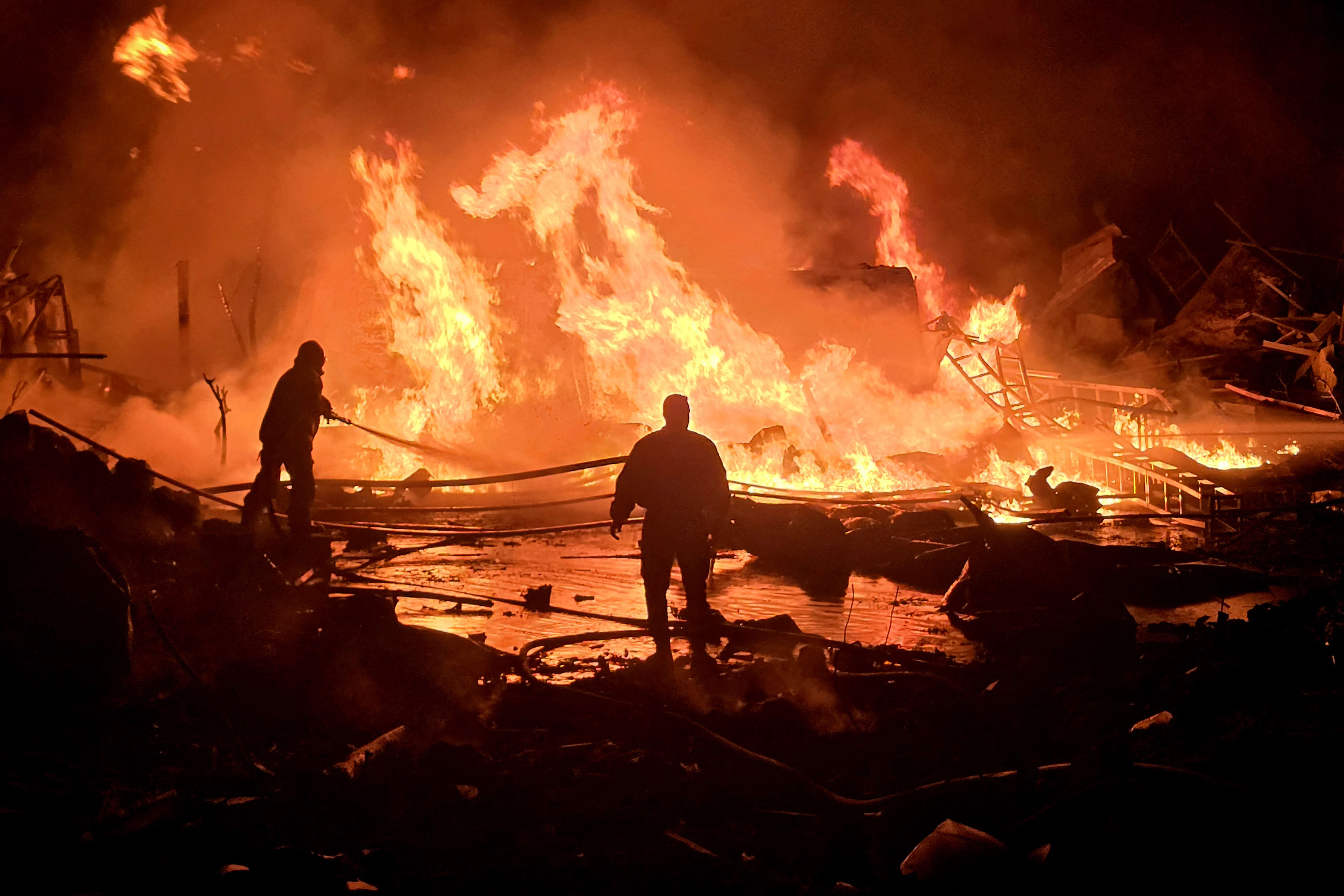 Forças de defesa civil tentam extinguir um incêndio que irrompeu após bombardeio israelense a uma fazenda solar e usina de geração de energia elétrica na cidade costeira de Tiro