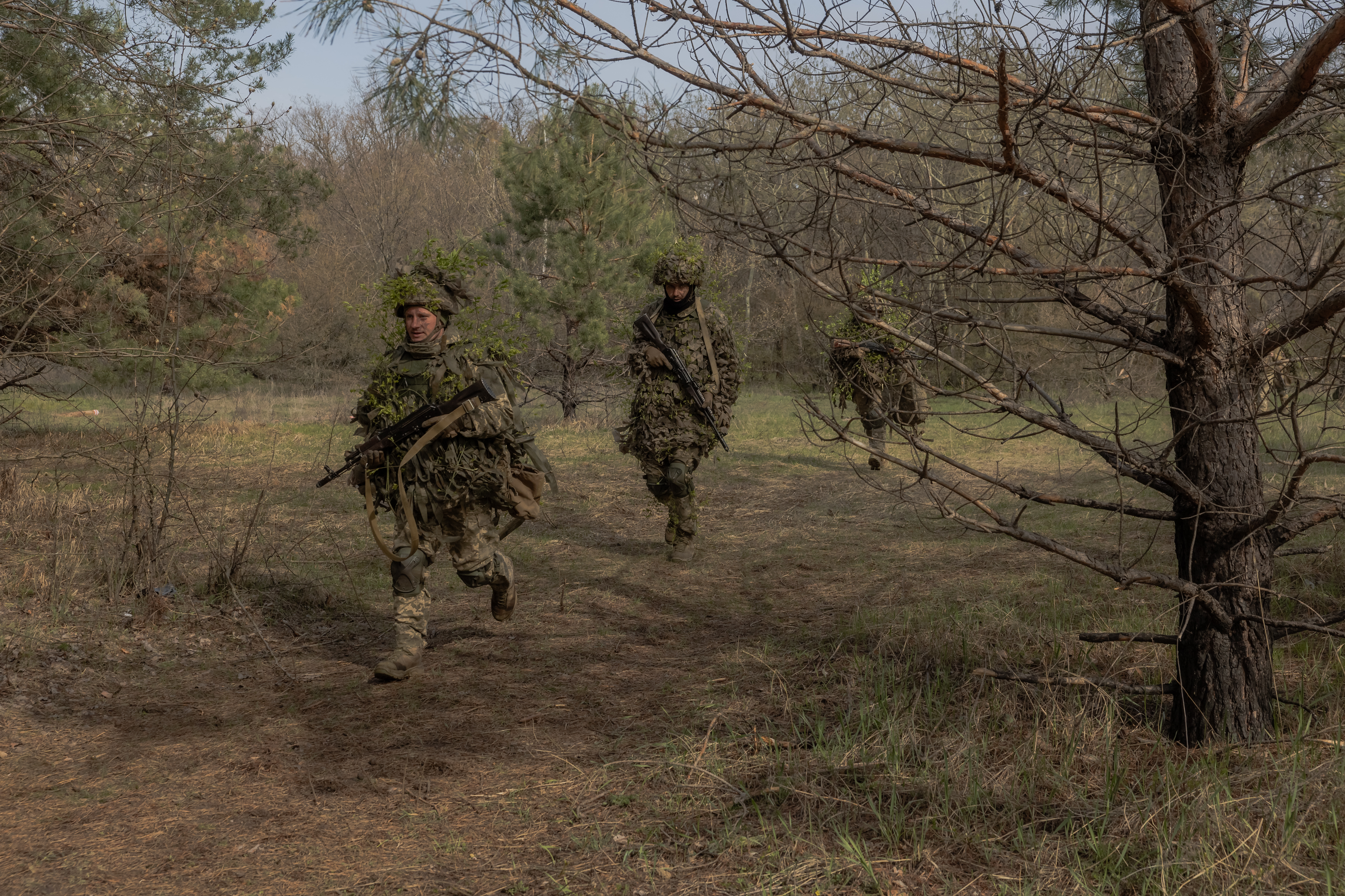 Militares ucranianos da 33ª Brigada Mecanizada Independente caminham após uma cerimônia religiosa para celebrar a Páscoa Ortodoxa, na região de Kharkiv, em 12 de abril de 2026, em meio à invasão russa da Ucrânia
