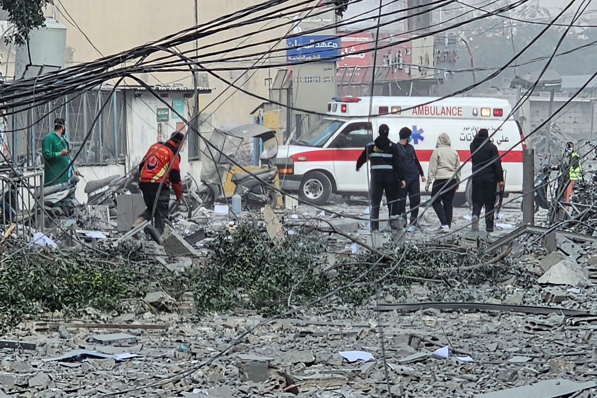 Equipes de resgate em meio aos destroços que cobrem uma rua após um ataque no subúrbio de Beirute