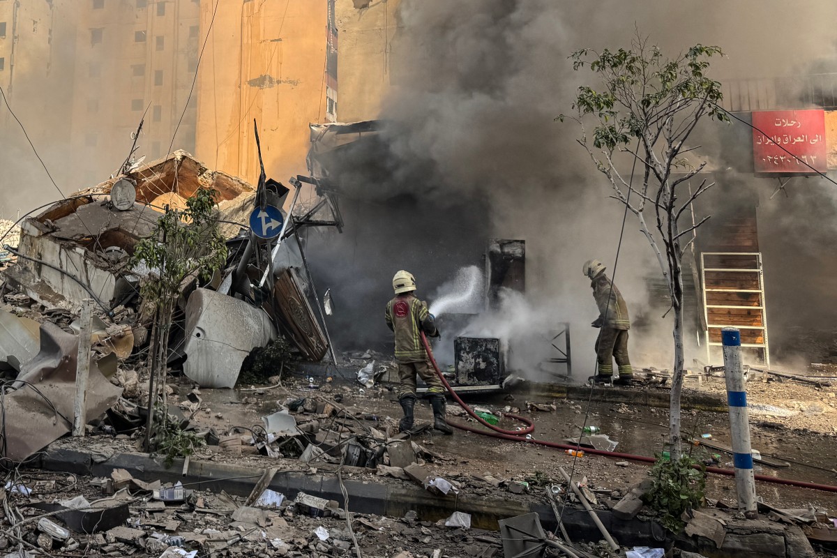 Bombeiros combatem um incêndio no local de um ataque aéreo israelense que teve como alvo o bairro de Haret Hreik