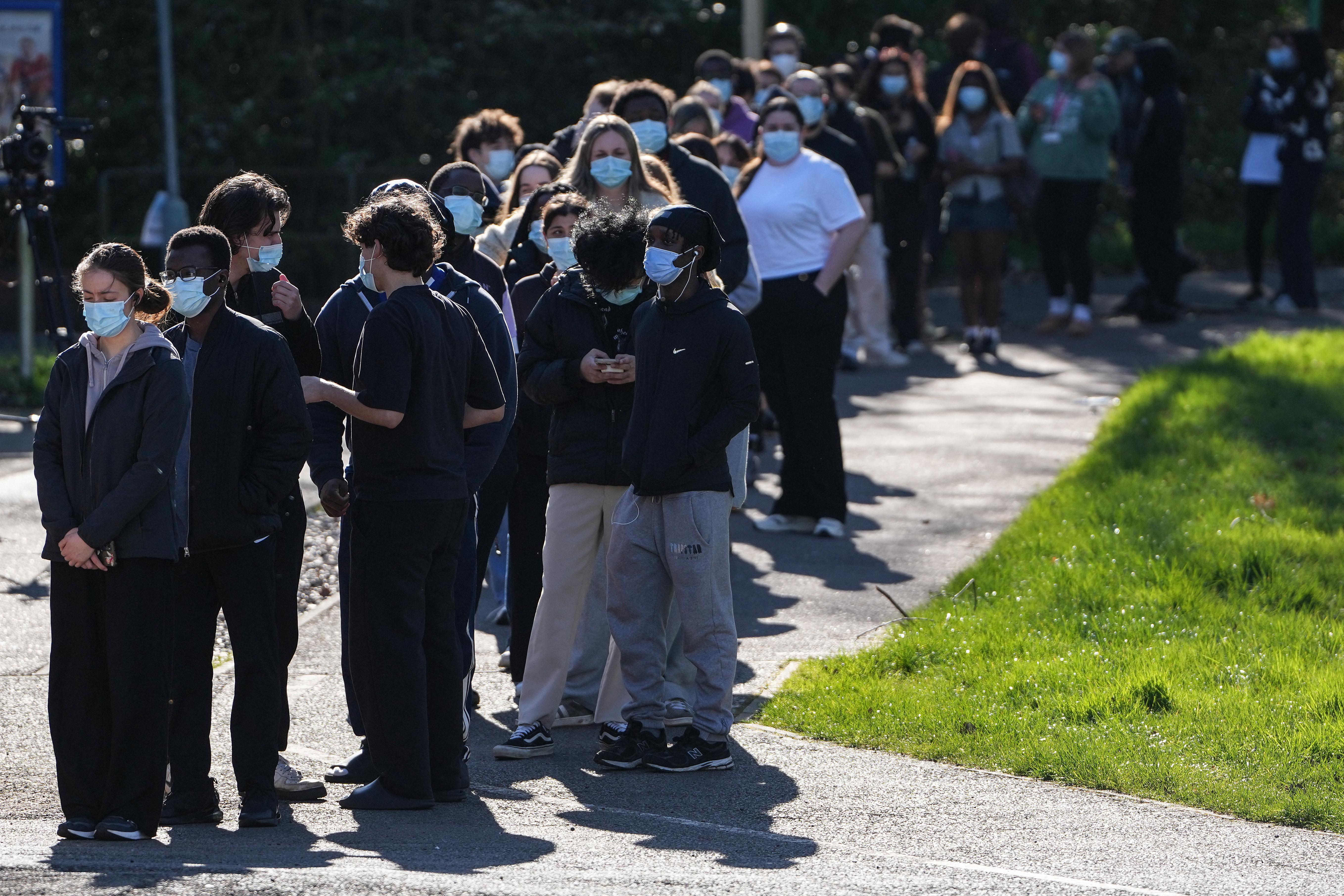 Dezenas de pessoas usando máscaras faciais fazem fila para serem vacinados na Universidade de Kent, em Canterbury, sudeste da Inglaterra