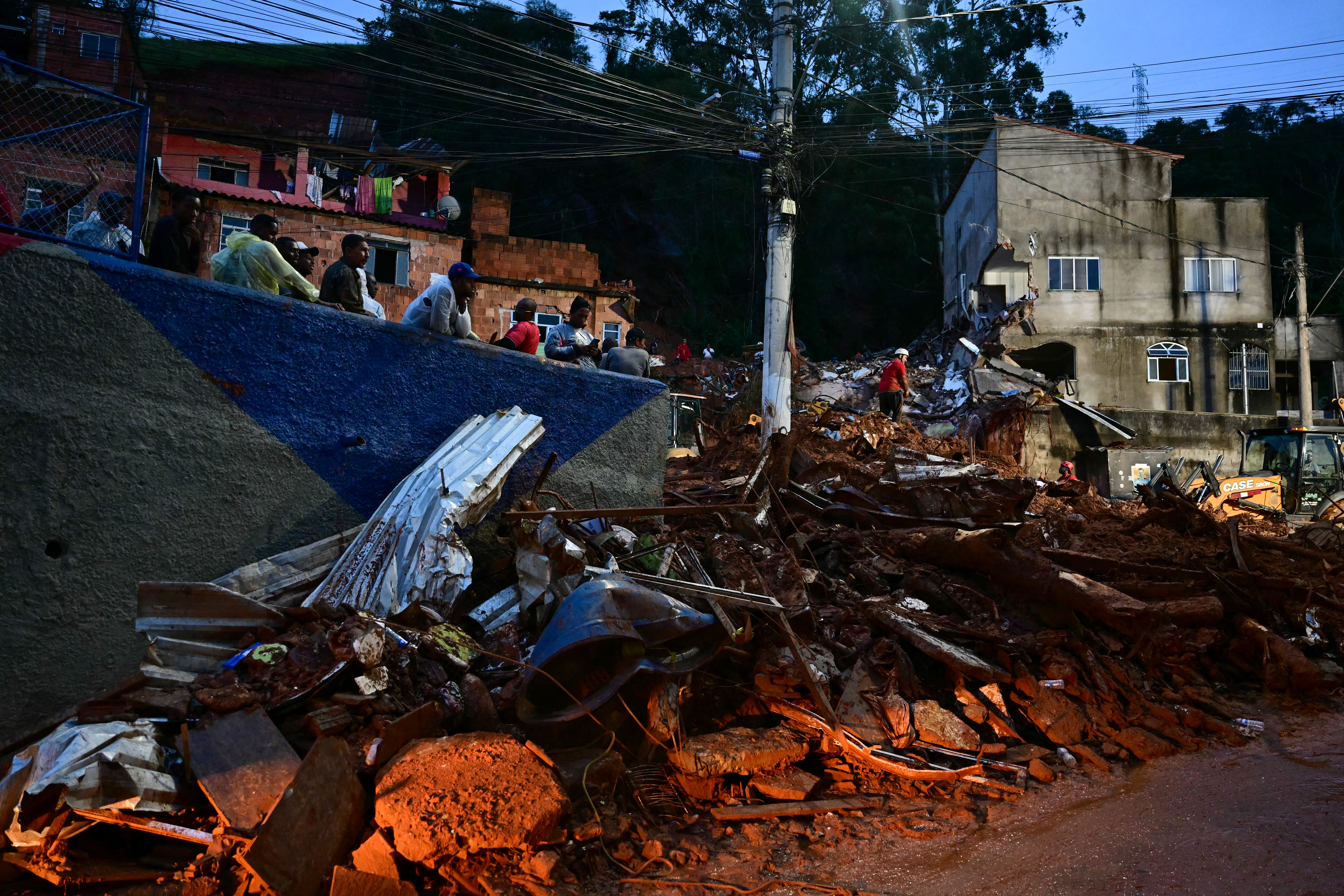 Pessoas observam equipes de resgate
