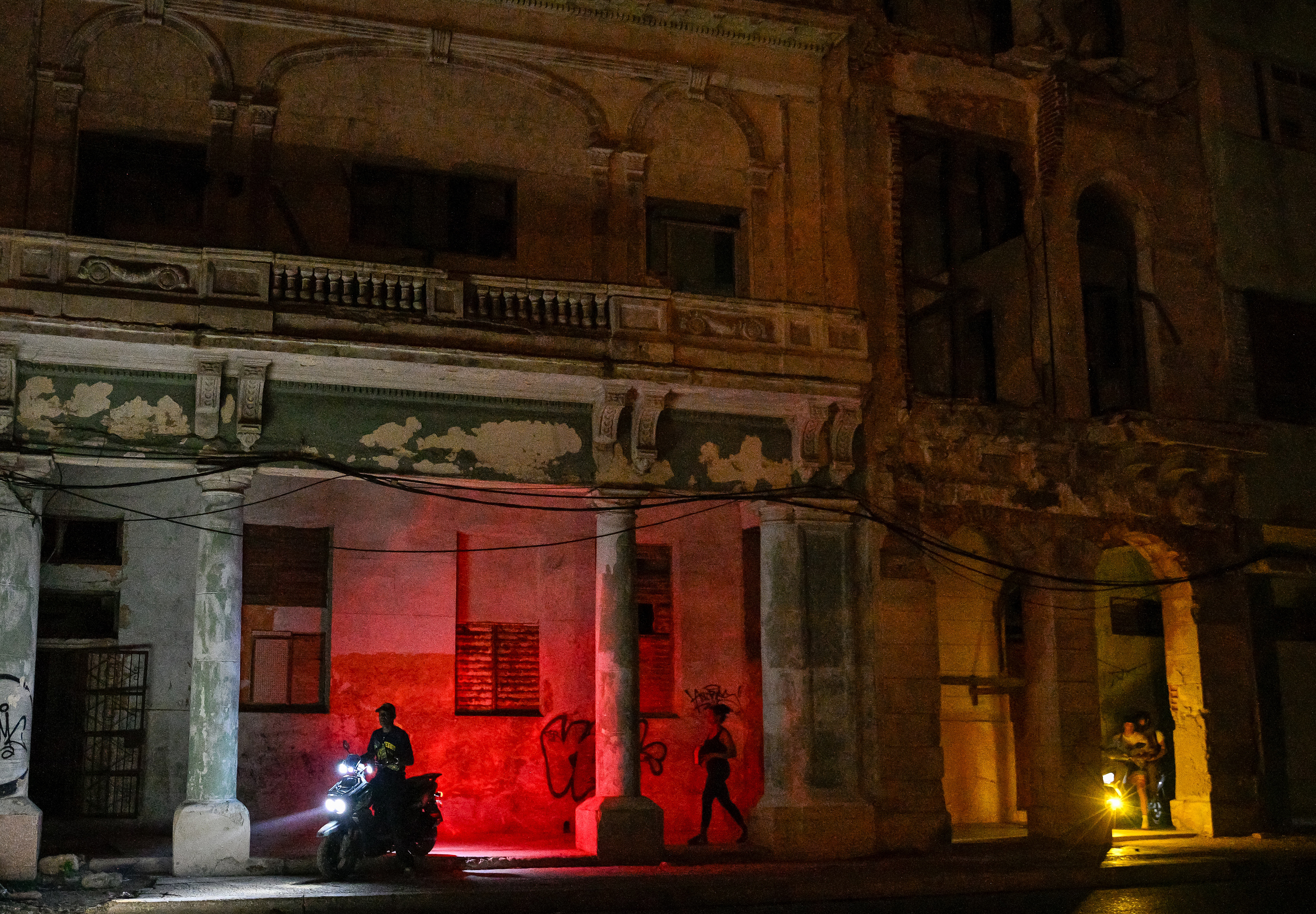Cubanos usam suas motocicletas durante um apagão em Havana