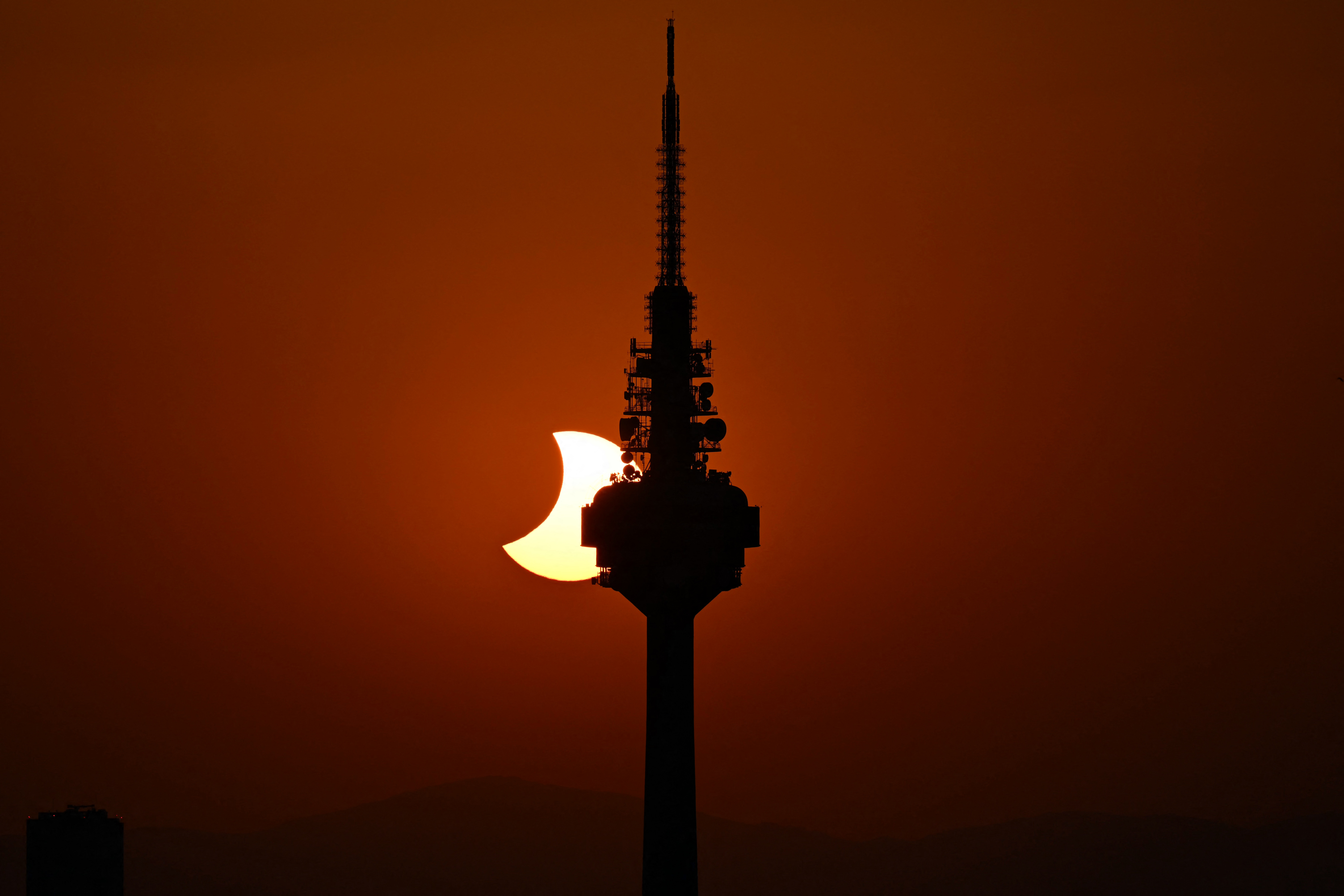 A Lua revela o Sol por trás da torre de TV Torrespaña — apelidada de "El Pirulí" — nos momentos finais do eclipse solar, visto do mirante Cuna Verde, em Madri, em 12 de agosto de 2026.