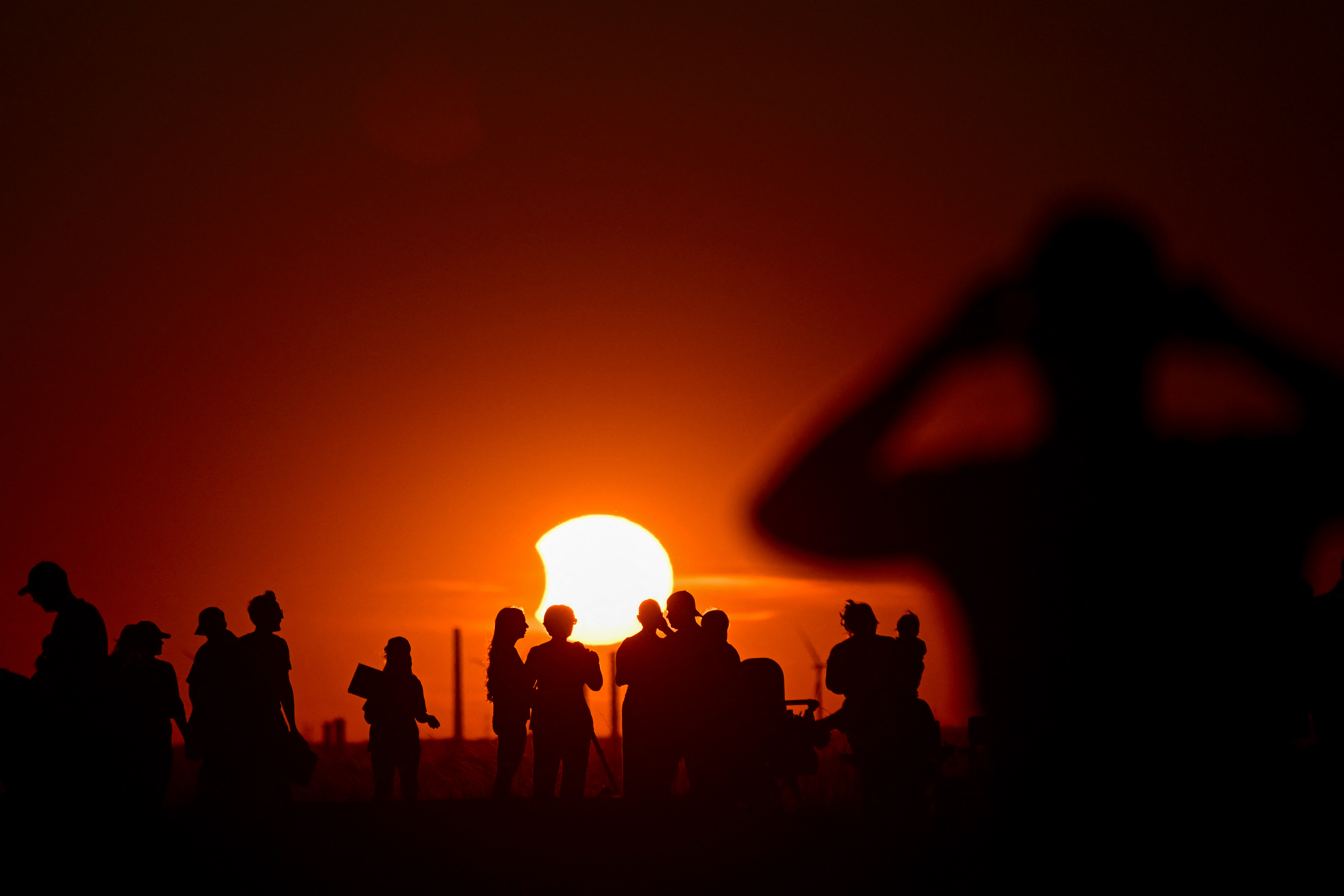 Pessoas observam o eclipse solar parcial no parque paisagístico Halde Hoheward, em Herten, no oeste da Alemanha, em 12 de agosto de 2026.