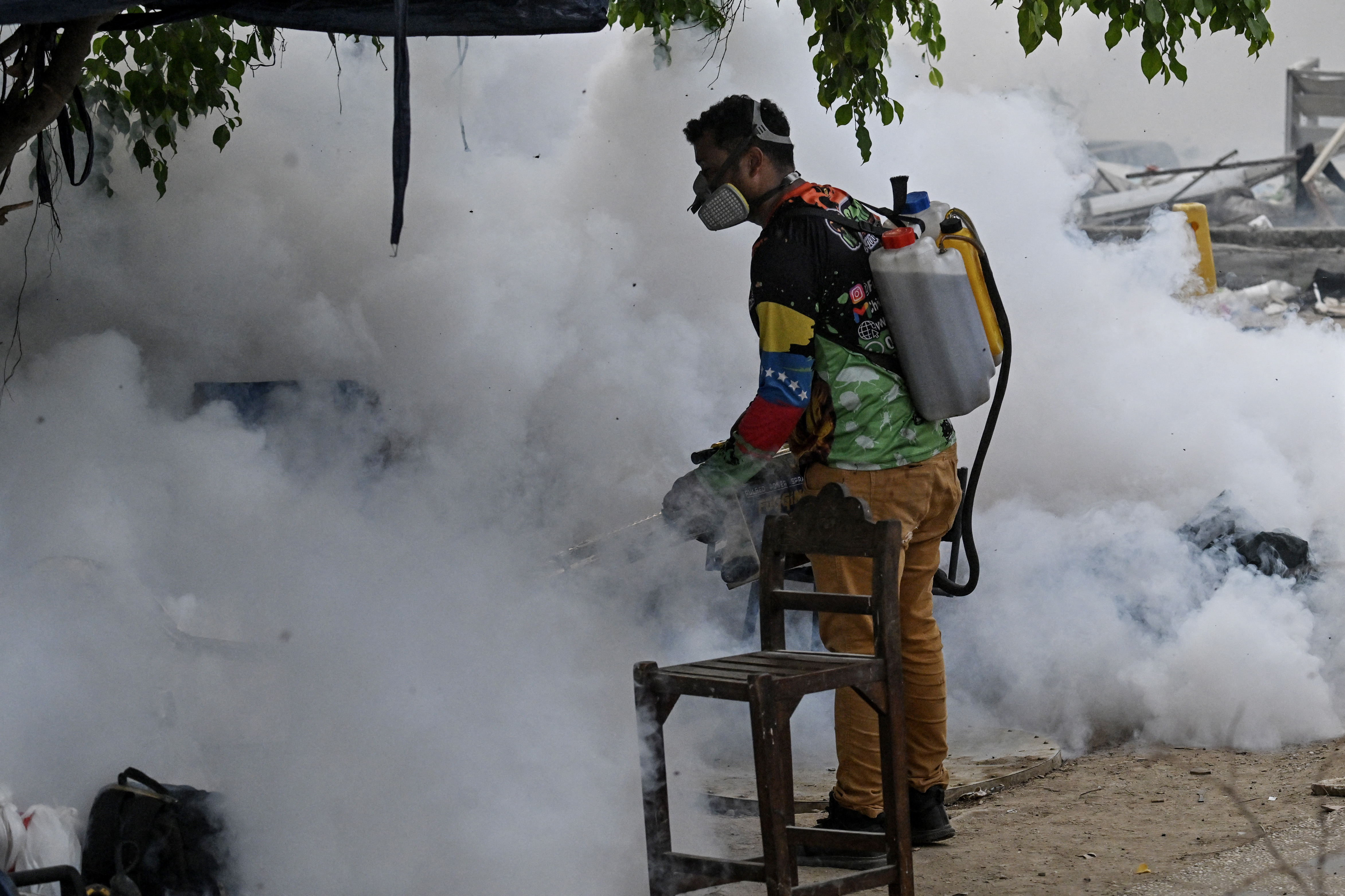 Um homem aplica pesticidas perto dos escombros de um prédio em Caraballeda, Venezuela, em 22 de julho de 2026, quase um mês após os terremotos de 24 de junho