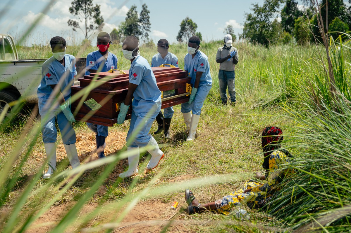 Membros de uma equipe da Cruz Vermelha Congolesa carregam o caixão de uma mulher com suspeita de morte por doença causada pelo vírus Ebola durante seu sepultamento seguro em um cemitério em Bunia, em 7 de junho de 2026. Um surto de Ebola na República Democrática do Congo matou 2.011 pessoas de um total de 4.381 casos confirmados do vírus, informaram autoridades congolesas na terça-feira.
