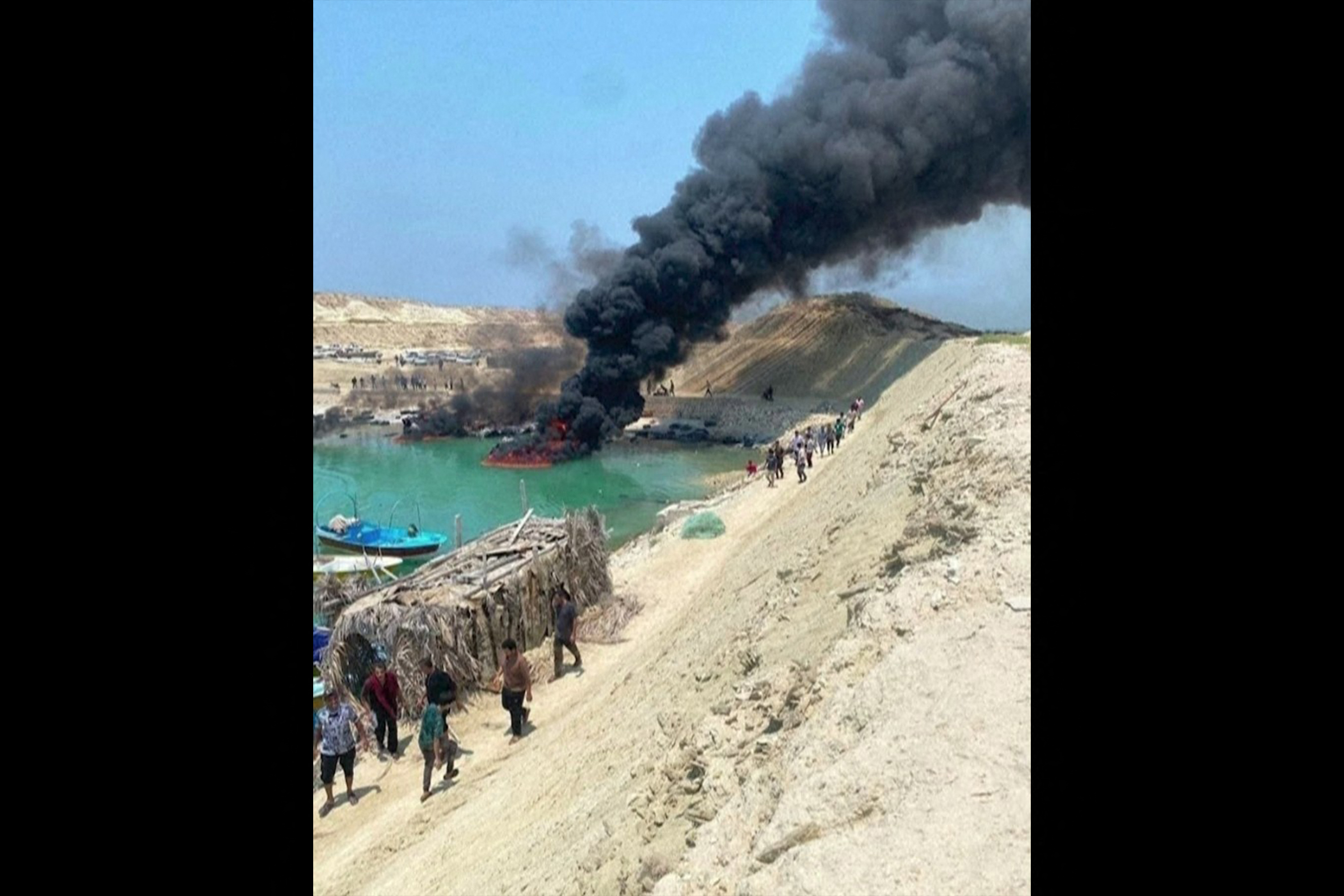 Nesta imagem extraída de um vídeo de conteúdo gerado pelo usuário (UGC) publicado nas redes sociais em 9 de julho de 2026, barcos de pesca aparecem em chamas no píer de Banud, na província de Bushehr, no sul do Irã. Em 9 de julho, a mídia estatal iraniana noticiou um ataque conjunto dos EUA e de Israel contra um quartel-general militar perto de Bushehr, onde está localizada a única usina nuclear civil do Irã.