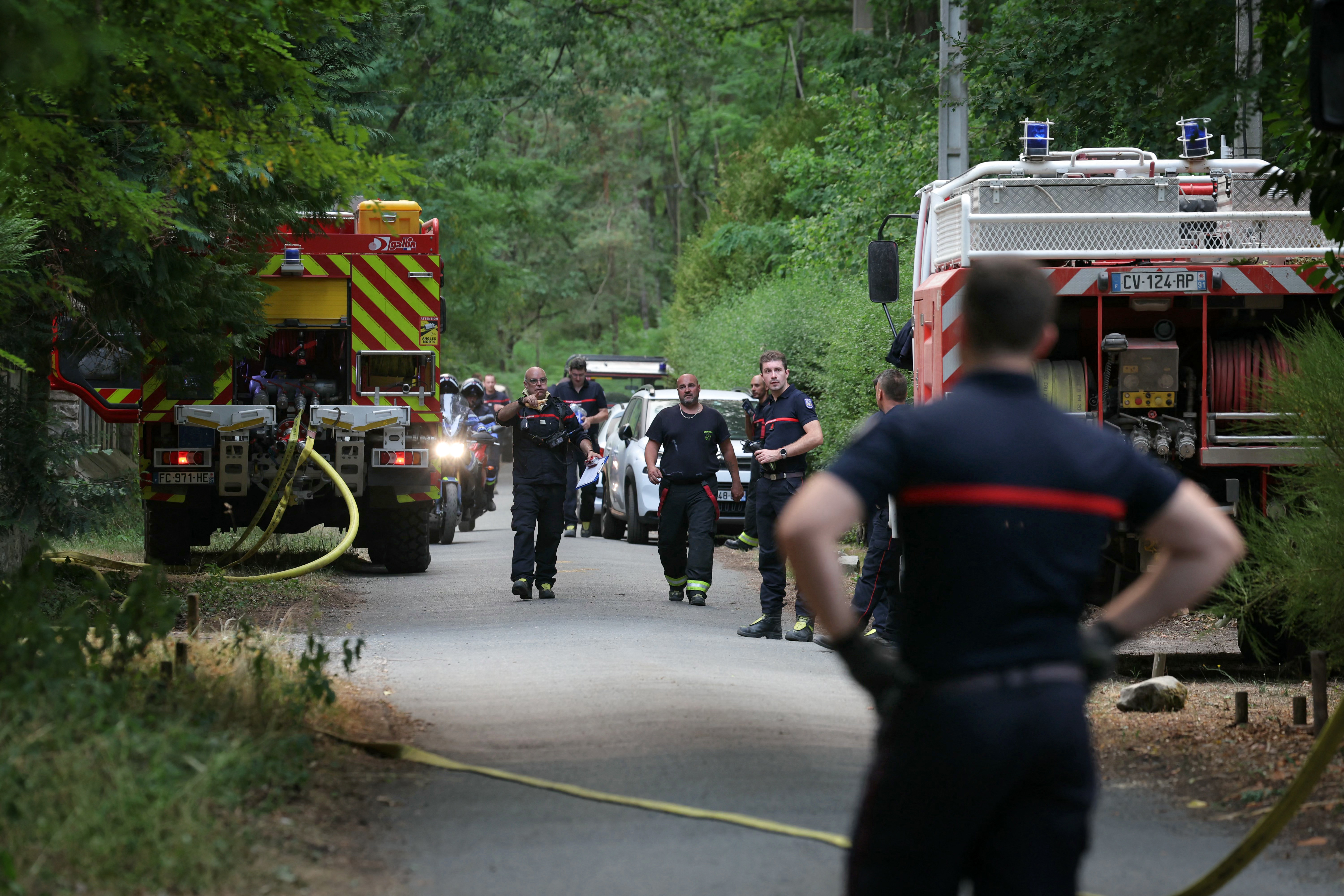 Caminhões de bombeiros abastecem seus tanques com água em uma manobra preventiva enquanto um incêndio florestal consome áreas próximas na floresta de Fontainebleau, nos arredores de Noisy-sur-École, em 13 de julho de 2026.