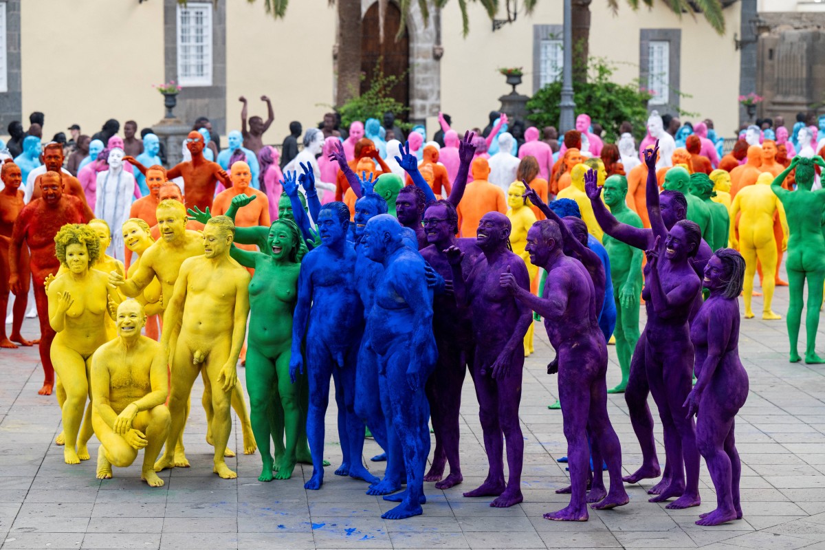 Participantes posam juntos após serem fotografados pelo norte-americano Spencer Tunick (não aparece na imagem) para sua intervenção artística coletiva "Grand Spectrum", na praça Santa Ana, no bairro de Vegueta, em Las Palmas de Gran Canaria, em 26 de julho de 2026.