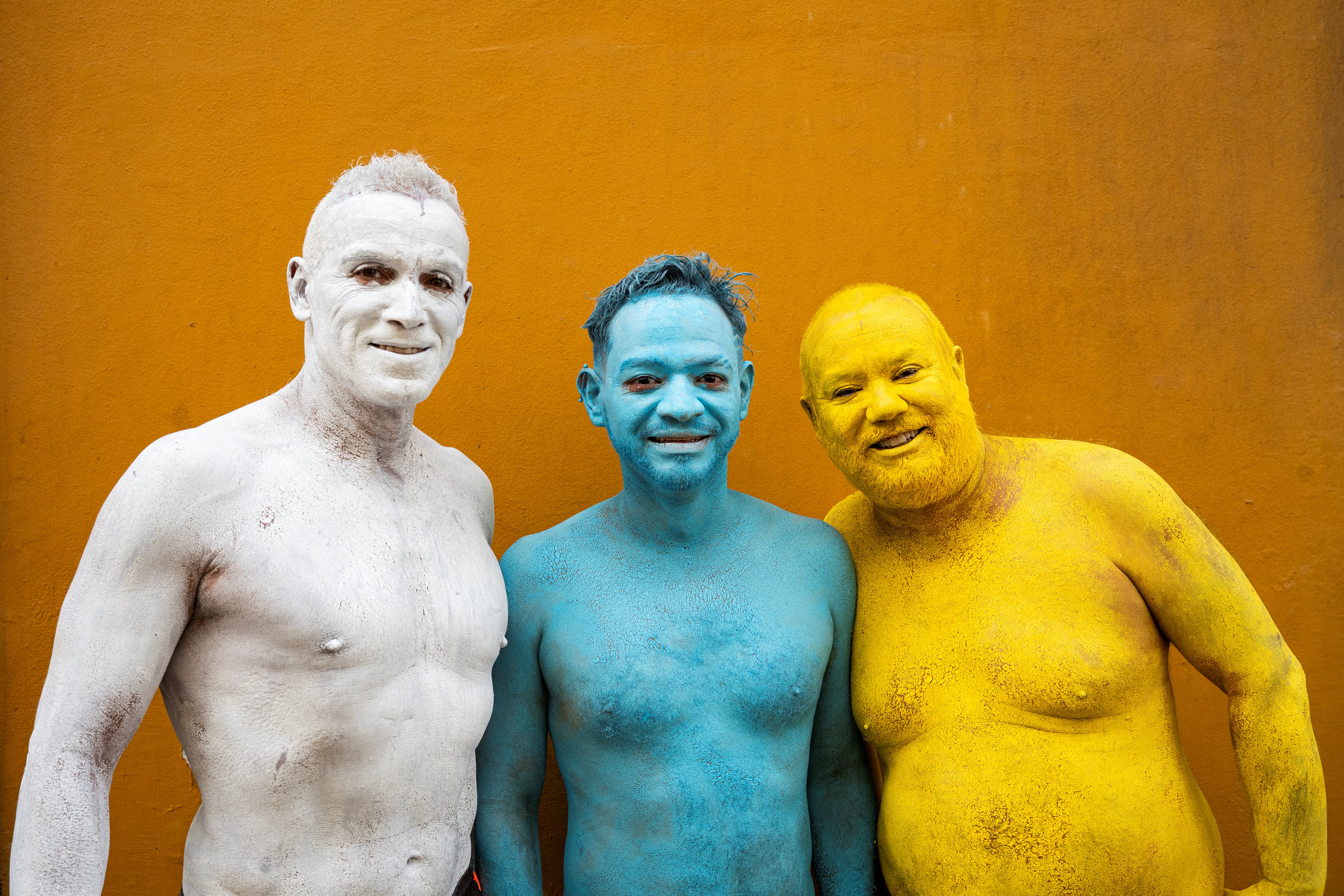 Participantes nus e com o corpo pintado posam juntos após participarem da sessão de fotos do fotógrafo americano Spencer Tunick (não aparece na imagem) para sua intervenção artística coletiva "Grand Spectrum", na praça Santa Ana, no bairro de Vegueta, em Las Palmas de Gran Canaria, em 26 de julho de 2026.