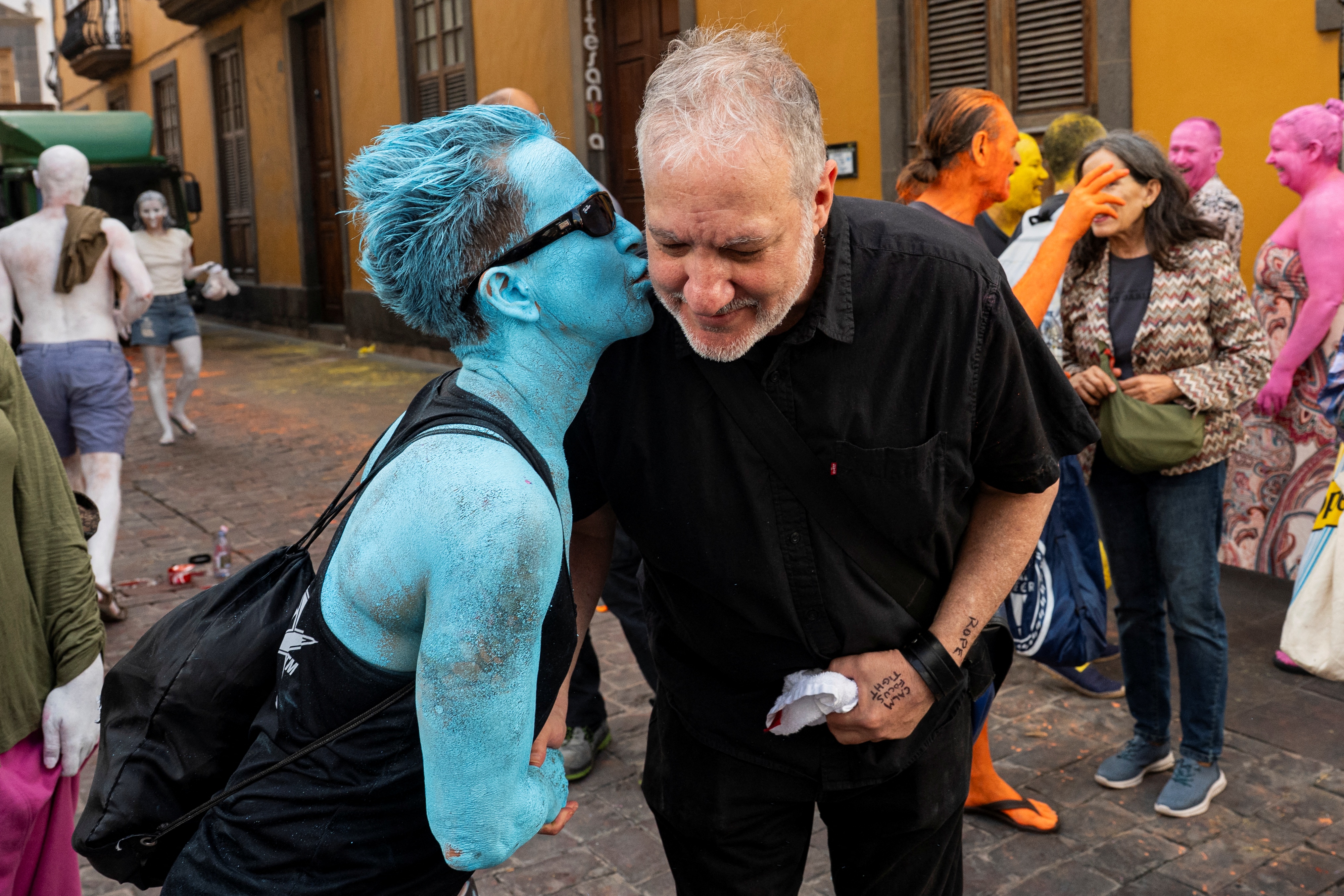 O fotógrafo americano Spencer Tunick (à direita) é cumprimentado por um participante após realizar fotos para sua intervenção artística coletiva "Grand Spectrum" na praça Santa Ana, no bairro de Vegueta, em Las Palmas de Gran Canaria, em 26 de julho de 2026.