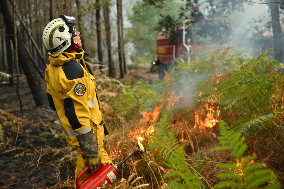 Bombeiros criam aceiros em uma floresta próxima a uma fazenda para impedir a propagação de um incêndio florestal em Luglon, no sudoeste da França, em 16 de agosto de 2026.