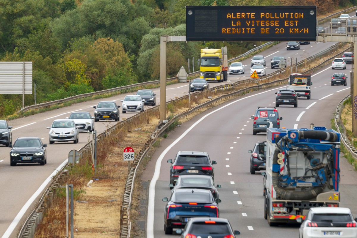 Carros passam sob um painel com a mensagem "Alerta de poluição – limite de velocidade reduzido em 20 km/h" na rodovia A31 em Bertrange, no nordeste da França, em 18 de agosto de 2026.