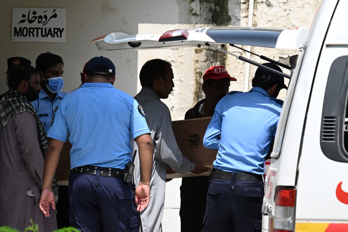 Policiais transferem um caixão contendo uma criança para uma ambulância após um incêndio na ala de saúde materno-infantil do Hospital do Instituto de Ciências Médicas do Paquistão (PIMS), em Islamabad, em 26 de agosto de 2026.