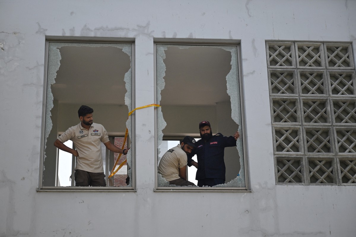 Policiais observam a cena através de janelas quebradas após um incêndio ocorrido do lado de fora da ala de Saúde Materno-Infantil (MCH) do Hospital do Instituto de Ciências Médicas do Paquistão (PIMS), em Islamabad, em 26 de agosto de 2026.