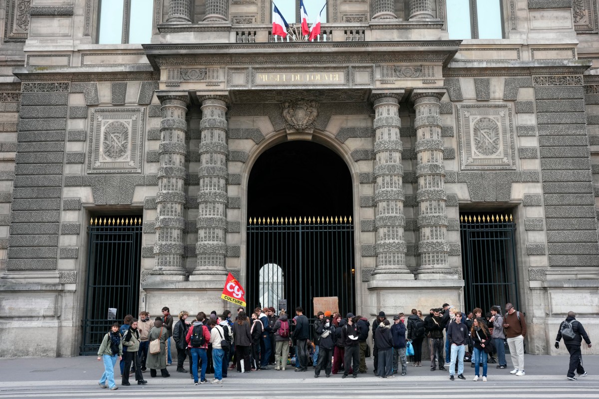 Manifestantes, incluindo estudantes da École du Louvre, bloquearam a entrada do Museu do Louvre para expressar seu apoio ao movimento dos estudantes do ensino médio e denunciar a repressão policial em Paris, em 19 de outubro de 2026 (Foto de Dimitar Dilkoff/AFP)