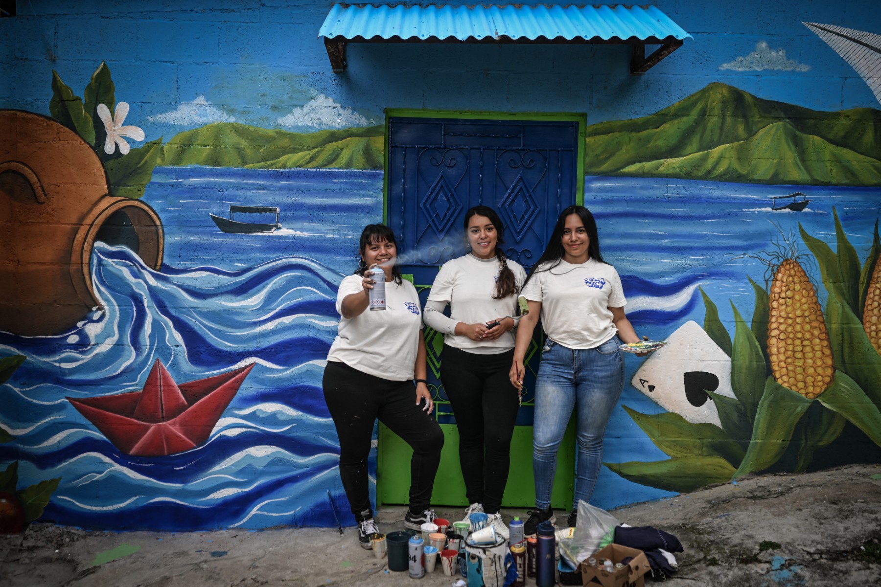 A artista salvadorenha Marcela Alvarenga segura uma paleta de pintura enquanto trabalha no mural "Identidade", na comunidade 10 de Octubre, em San Marcos, El Salvador.
