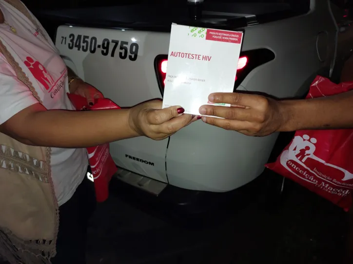 Momento da entrega de um autoteste de HIV durante a 'Ronda Noturna'