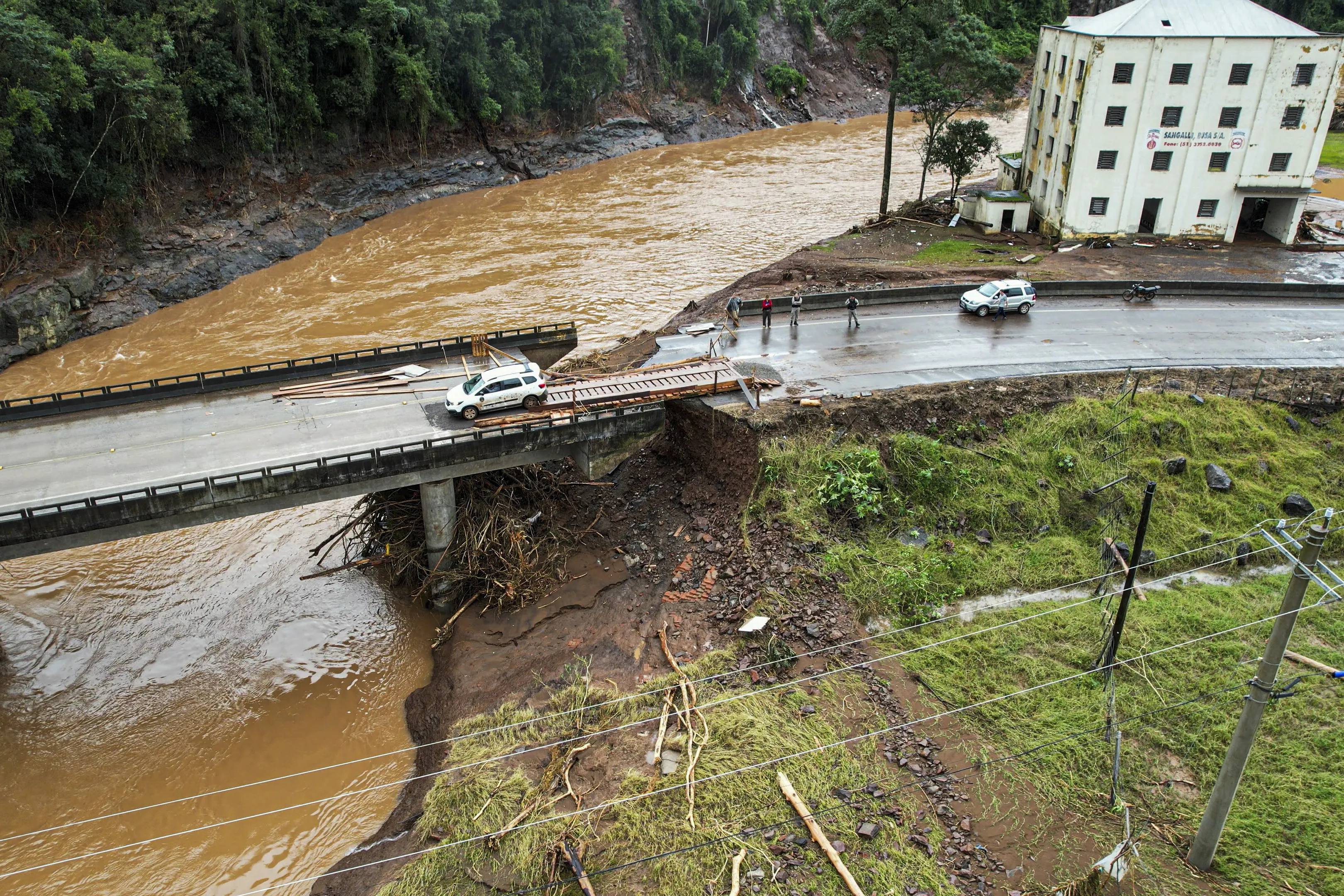 Aerial view of a bridge partially destroyed by floods in Encantado, Rio Grande do Sul state, Brazil on May 5, 2024. Authorities in southern Brazil scrambled Sunday to rescue people from raging floods and mudslides in what has become the region's largest ever climate catastrophe, with at least 78 dead and 115,000 forced from their homes. (Photo by Gustavo Ghisleni / AFP)