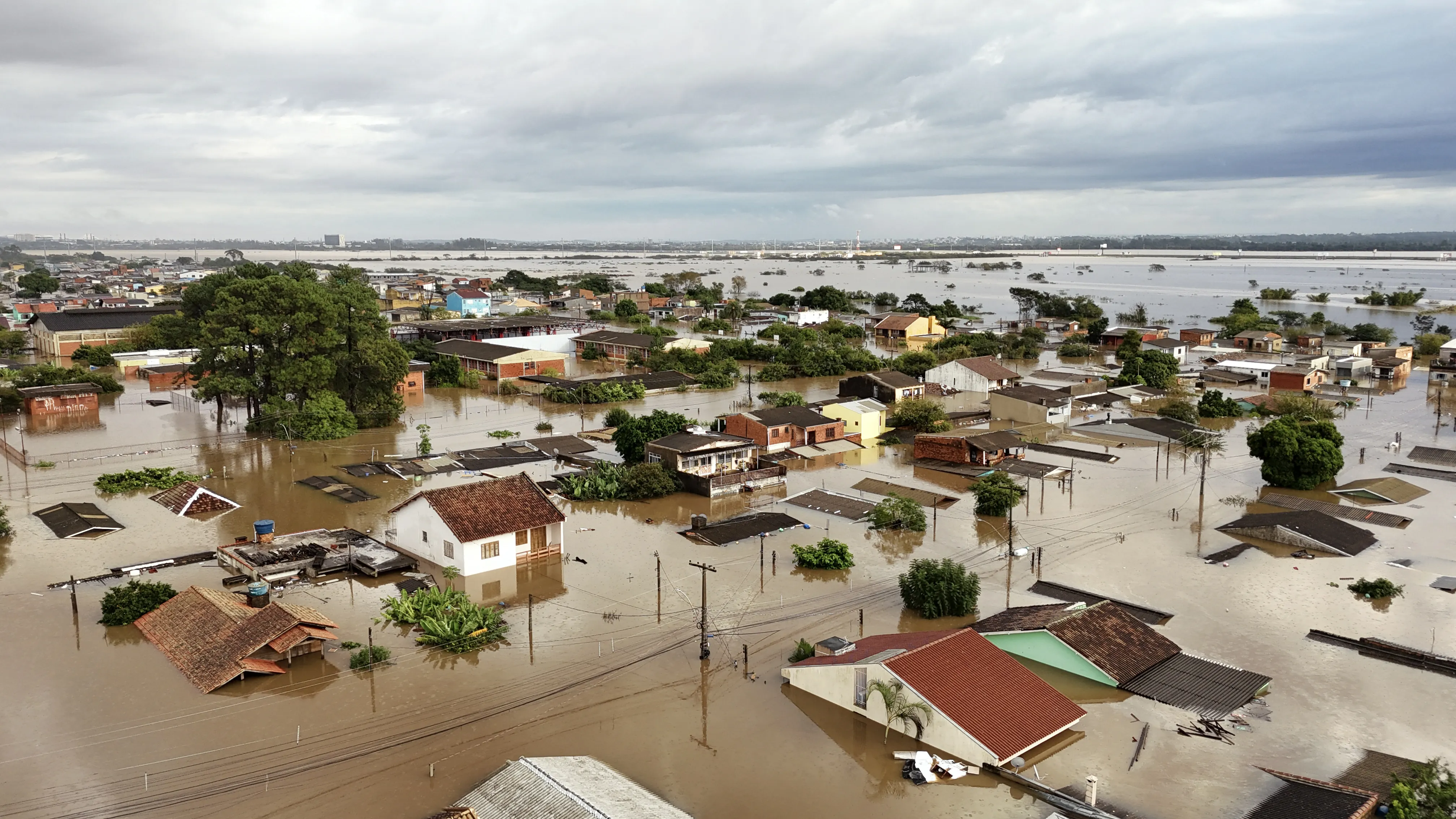Aerial view of flooded streets at the Sarandi neighborhood in Porto Alegre, Rio Grande do Sul state, Brazil on May 5, 2024. The challenge is titanic and against the clock: authorities and neighbours are trying to avoid an even greater tragedy than the one already experienced in the Brazilian state of Rio Grande do Sul, where 66 people died and 80,000 were displaced by the floods, according to the authorities. (Photo by Carlos Fabal / AFP)