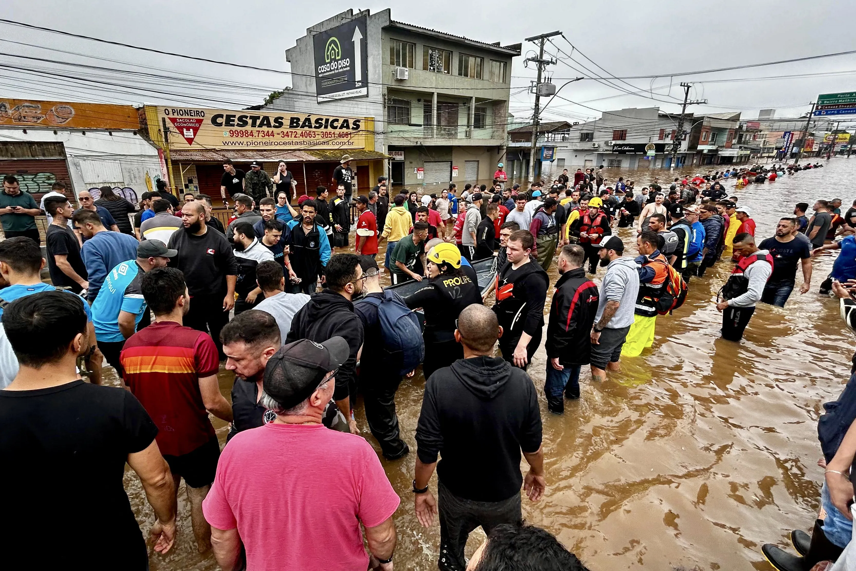 This handout picture released by the Canoas City Hall shows rescue teams and volunteers helping flood victims in Canoas, Rio Grande do Sul state, Brazil on May 4, 2024. The challenge is titanic and against the clock: authorities and neighbours are trying to avoid an even greater tragedy than the one already experienced in the Brazilian state of Rio Grande do Sul, where 66 people died and 80,000 were displaced by the floods, according to the authorities. (Photo by Alisson MOURA / Canoas City Hall / AFP) / RESTRICTED TO EDITORIAL USE - MANDATORY CREDIT "AFP PHOTO / CANOAS CITY HALL / ALISSON MOURA" - NO MARKETING NO ADVERTISING CAMPAIGNS - DISTRIBUTED AS A SERVICE TO CLIENTS
