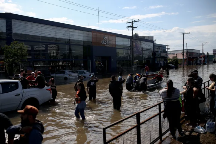 Army members, firefighters, healthcare personnel and volunteers participate in the rescue operation of neighbours from Sarandi neighborhood, whose houses were affected by the floods, in Porto Alegre, Rio Grande do Sul state, Brazil on May 5, 2024. The challenge is titanic and against the clock: authorities and neighbours are trying to avoid an even greater tragedy than the one already experienced in the Brazilian state of Rio Grande do Sul, where 66 people died and 80,000 were displaced by the floods, according to the authorities. (Photo by Anselmo Cunha / AFP)