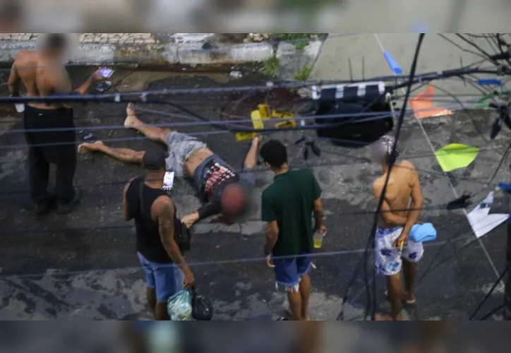 Curiosos observam o corpo da vítima