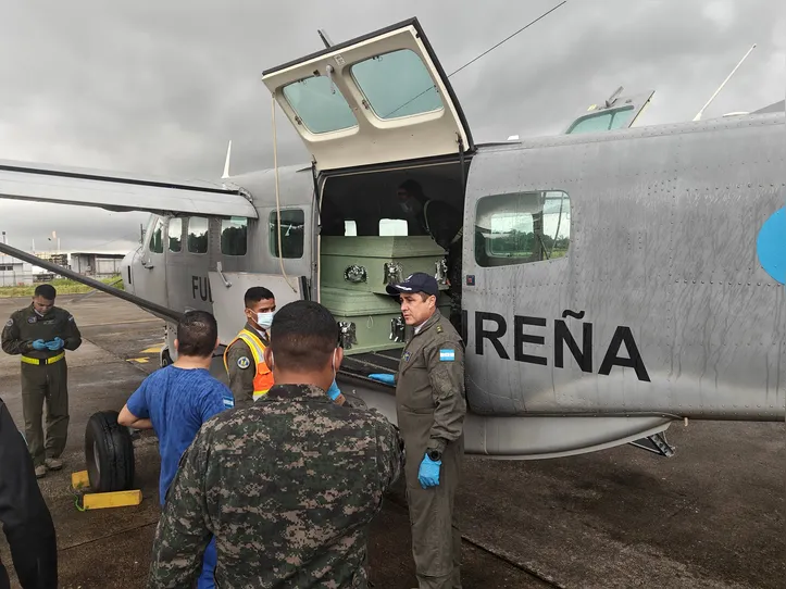 Soldados da Força Aérea de Honduras levam corpos em caixões