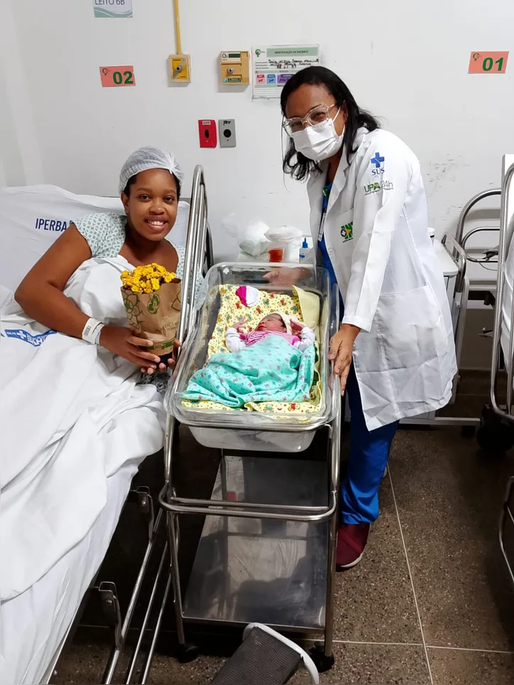 Mãe, Iria Nilza Soares Nascimento e sua filha, Vitória, junto de uma das doutoras