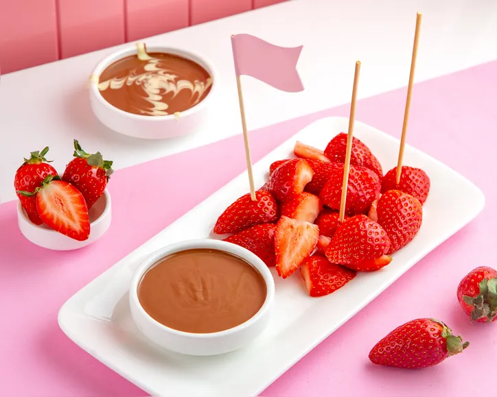 side view strawberry chocolate fondue with melted chocolate and strawberry on the table