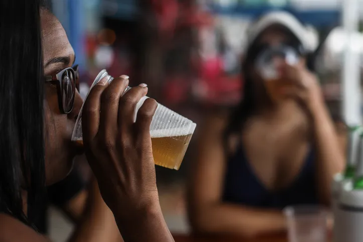 Mulher segurando copo de cerveja