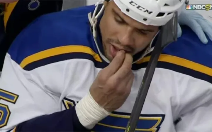 Jogador de hóquei arrancando o próprio dente no banco de reservas