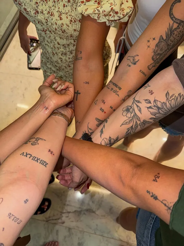 Virgínia e amigas exibem o "+34" tatuado no braço