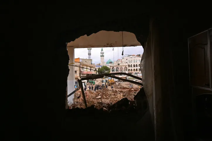This photograph taken during a media tour organised by the Hezbollah shows people inspecting the destruction at Nabi Sheet town after an Israeli military operation in the Bekaa Valley of Lebanon, on March 7, 2026. Hezbollah on March 7 said it confronted Israeli troops that infiltrated an east Lebanon town overnight, with Lebanese authorities reporting at least 16 killed in Israeli strikes on the area. (Photo by FADEL itani / AFP)
