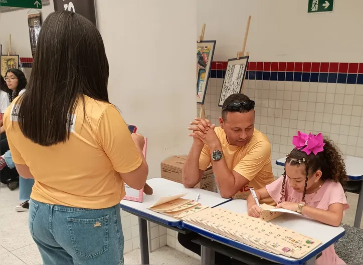 Luna e o pai Elmo autografando livros na Feira Literária Professora Benedita Ricarda