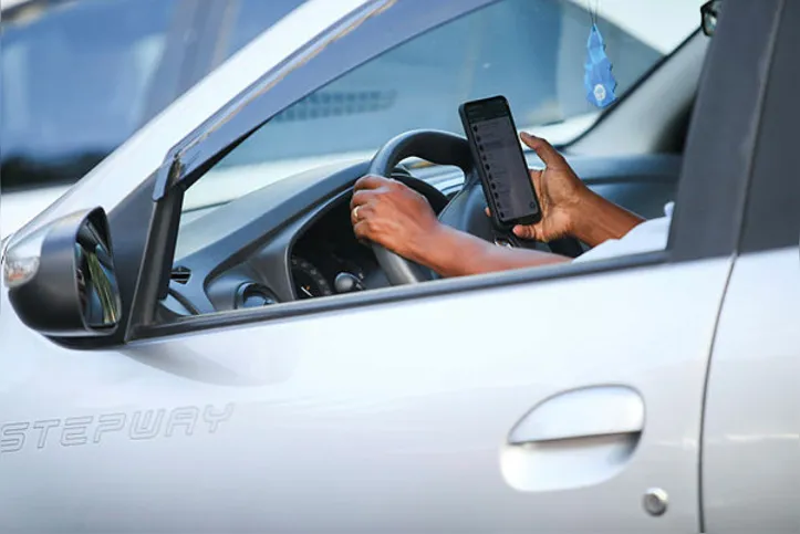 Homem ao celular no trânsito