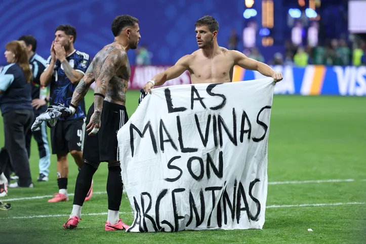 Otamendi e Lo Celso segurando a faixa das Malvinas