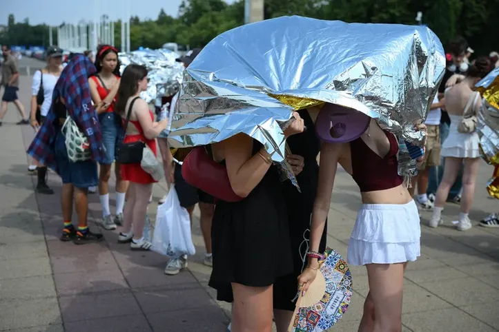 Pessoas com proteção de emergência contra o calor, a caminho de show de Bruno Mars, em Berlim, em 28 de junho