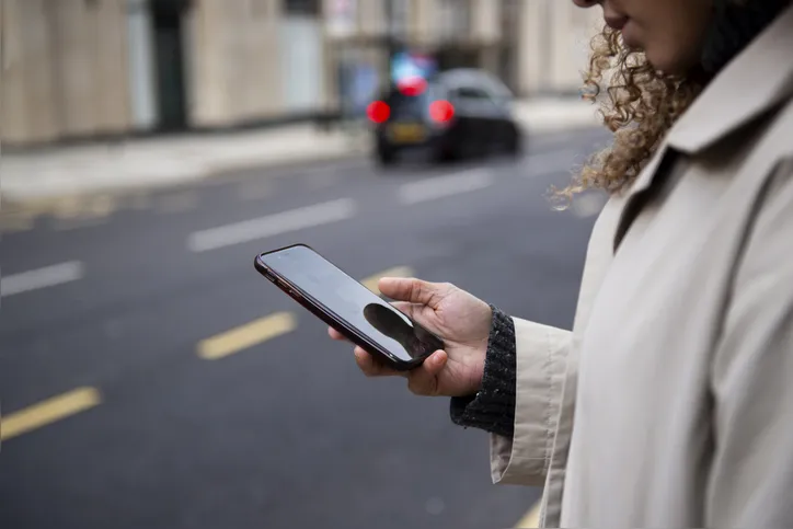 Pessoa utilizando celular na rua