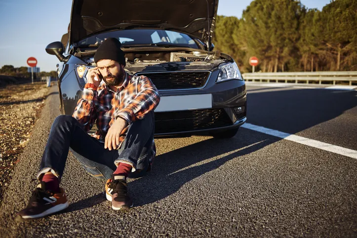 Homem parado em frente ao carro