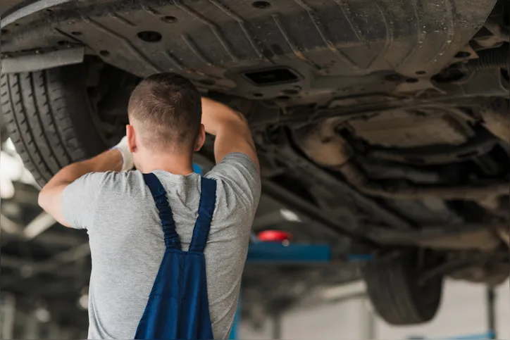 Mecânico mexendo na suspensão do carro