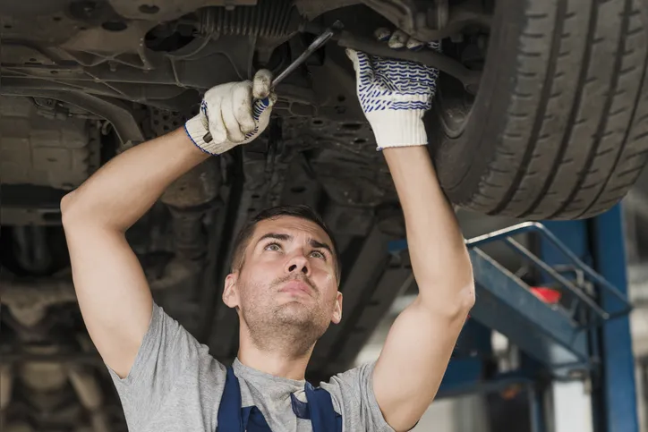 Mecânico mexendo na suspensão do carro