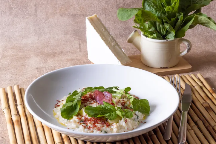 Risoto de queijo brie e rúcula é finalizado com presunto cru crocante